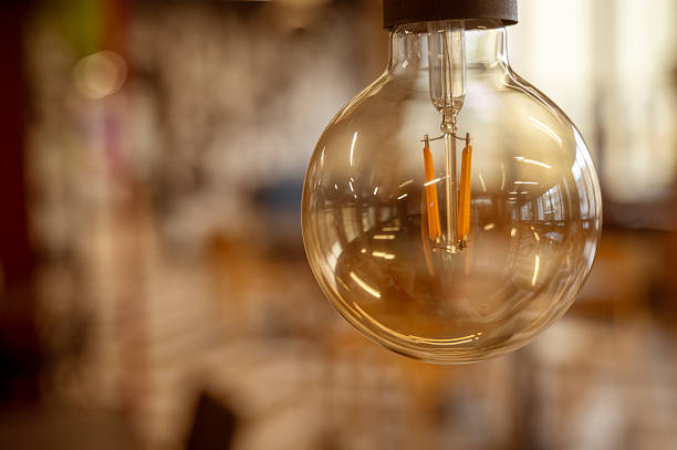 istock A classic designed tungsten lightbulb is glowing in orange warmlight shade with blurred background 2240289481