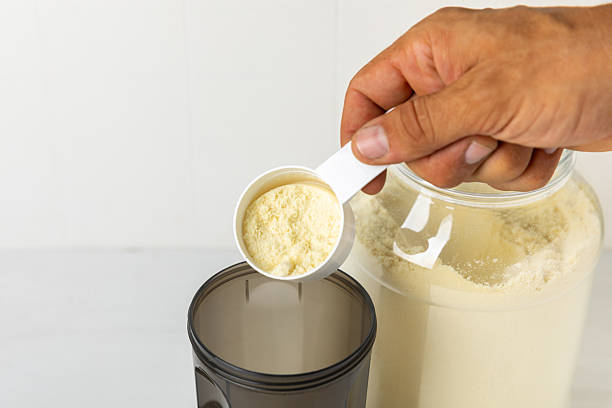 istock Protein shake with protein powder on a colored background. The powder is mixed with water or milk. A dietary supplement for a balanced diet. Whey protein. Fitness and gym diet nutrition. 2240290019