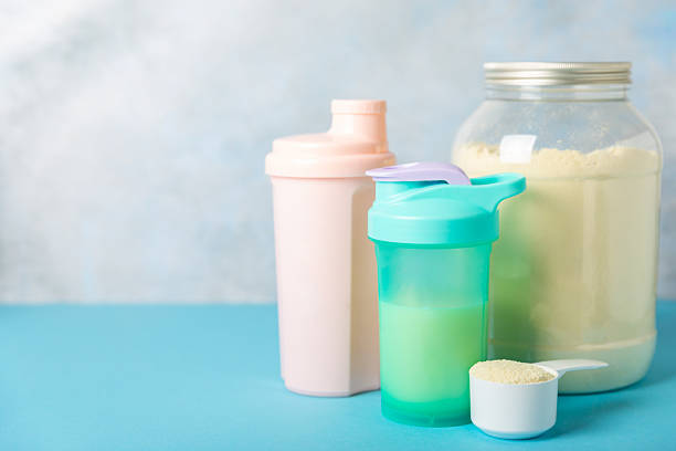 istock Protein shake with protein powder on a colored background. The powder is mixed with water or milk. A dietary supplement for a balanced diet. Whey protein. Fitness and gym diet nutrition. 2240290022