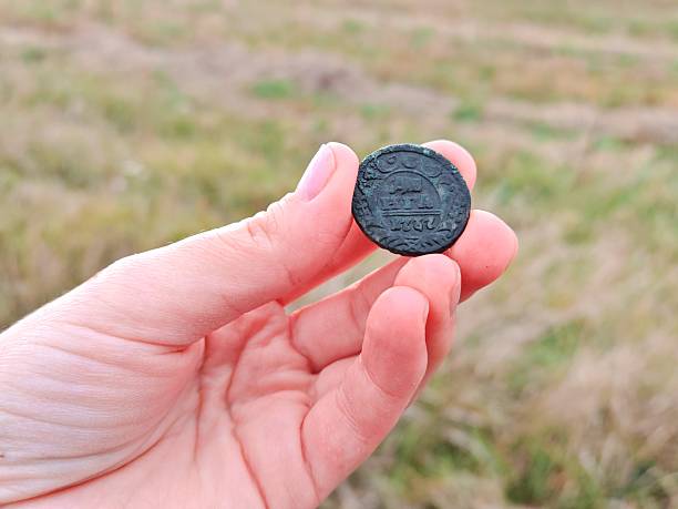 istock Ancient copper coin in hand of a treasure hunter 2240292500