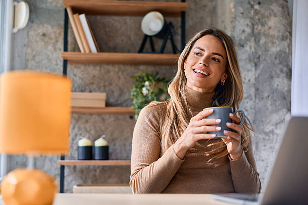 istock Woman relaxing office break, enjoying coffee, smiling 2240292928