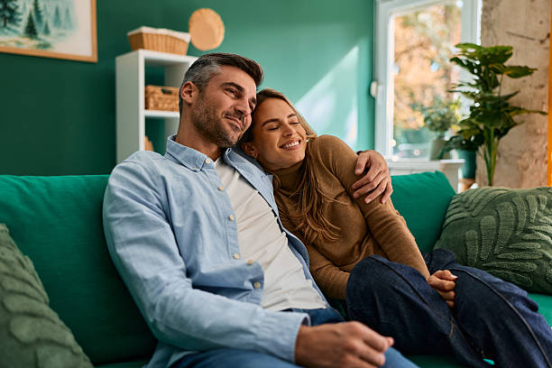 istock Happy couple relaxing at home on sofa together 2240292987