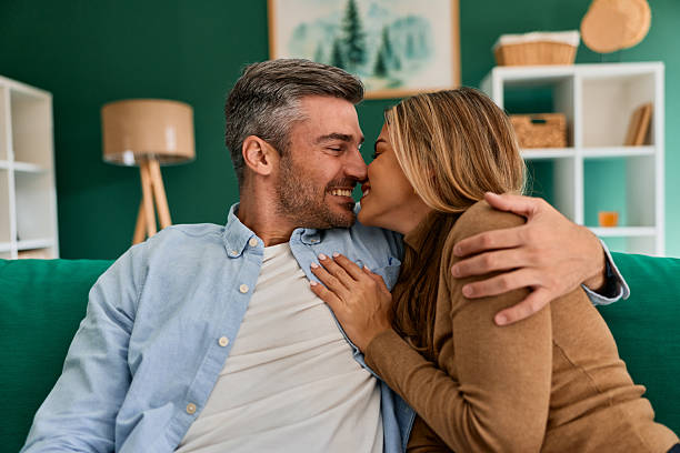 istock Happy couple embracing on sofa sharing intimate moment 2240292988
