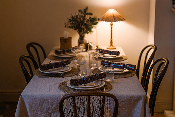 istock Warmly lit festive dinner table with rustic decor, Christmas crackers, candles, and a cozy winter atmosphere. 2240294474