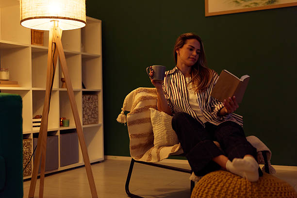 istock Woman relaxing at home reading book with warm drink 2240294645