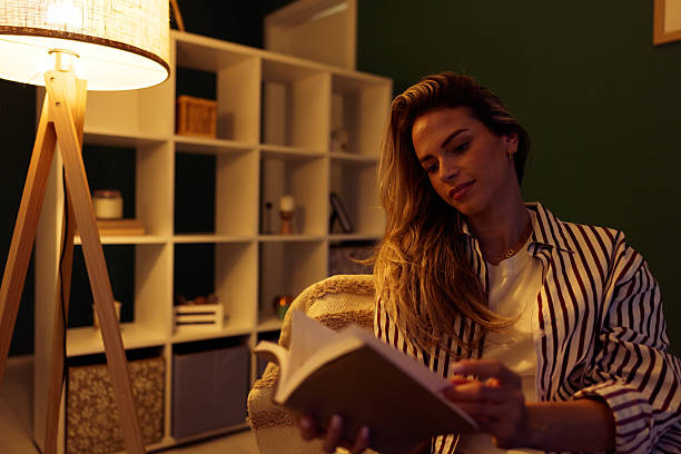 istock Woman relaxing at home, enjoying a book 2240294646