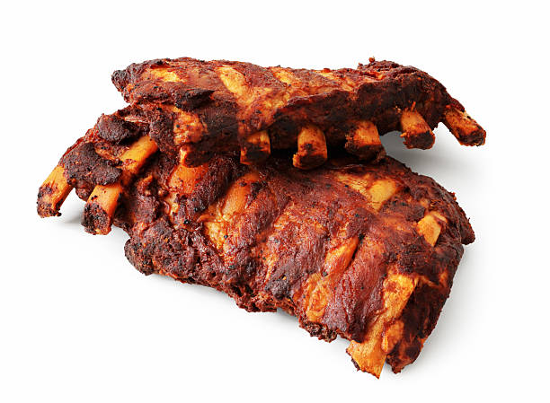 Grilled pork ribs with spices and vegetables on a wooden background