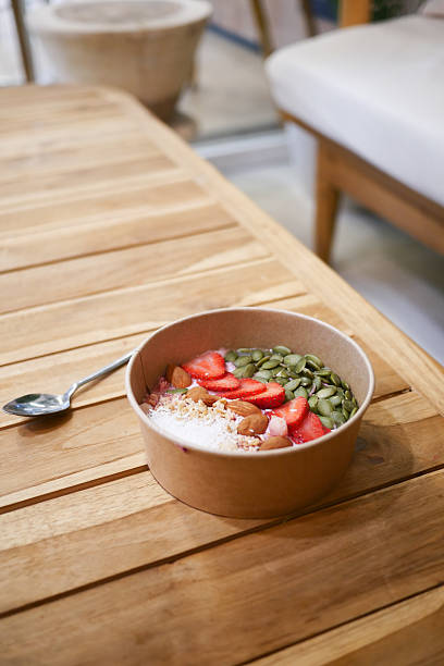 istock Healthy breakfast bowl with strawberries and nuts on table 2240305829