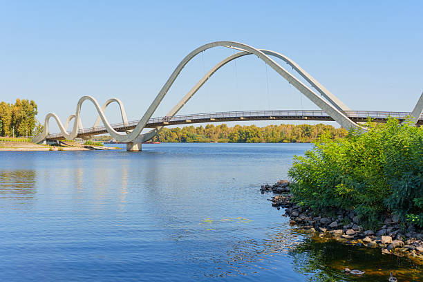 istock Stunning Wave Pedestrian Bridge Over Serene Waters in Kyiv Showcasing Modern Architecture 2240307218