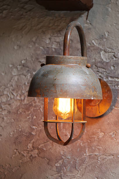 istock Rustic metal lamp hanging on a textured wall in warm lighting 2240308255