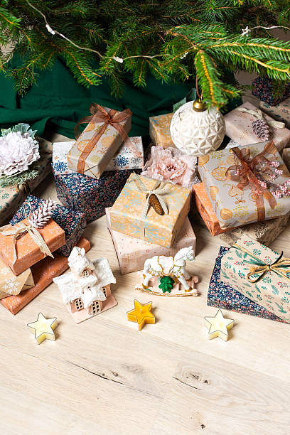 istock A cozy Christmas scene with elegant natural-toned gift boxes placed under a Christmas tree, lit with festive lights, evoking peace and seasonal joy 2240312788