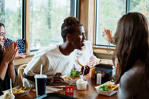 A young man looks at a photo on his friend's camera as they eat with friends at a casual restaurant while spending the Fourth of July together at Yellowstone National Park in Wyoming.