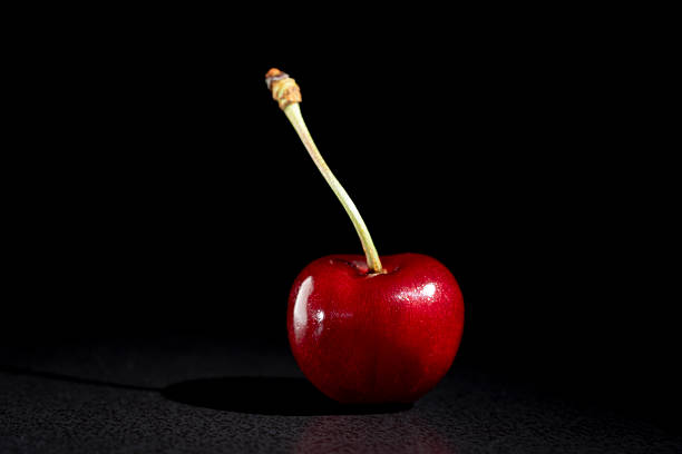 Juicy red cherry on black background. Fresh sweet cherry, close up