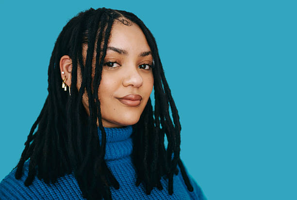 istock Confident young Black woman with dreadlocks wearing blue turtleneck against bright blue background 2240316577