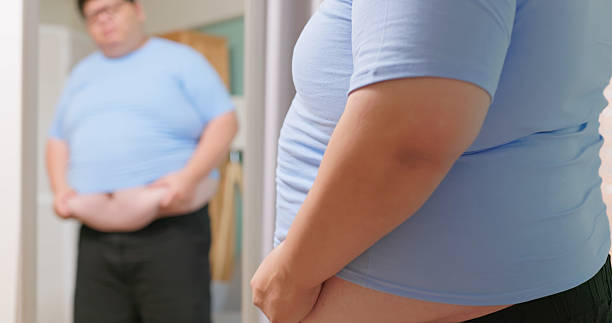 istock obese man in front of mirror 2240326181