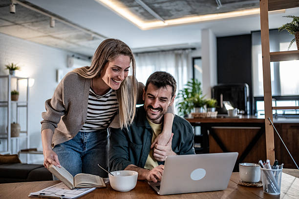 istock Couple working together on laptop at home 2240329095