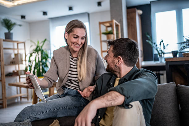 istock Happy couple laughing and bonding using digital tablet 2240330008