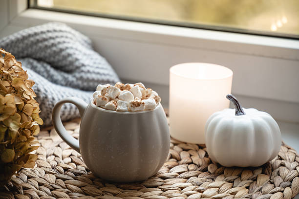 istock Autumn warming chocolate or coffee on windowsill. Autumn beverage 2240332030
