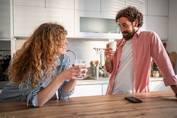 istock Couple drinking milk and talking in kitchen during morning 2240333566