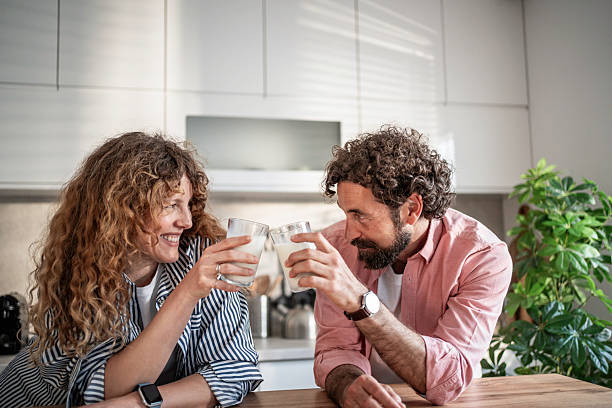 istock Couple toasting with milk in kitchen during breakfast 2240333567