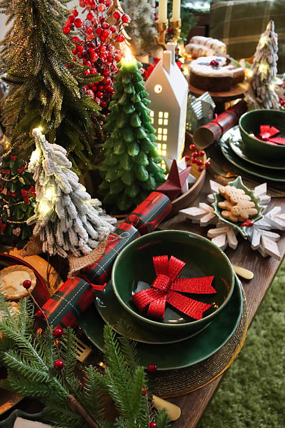 istock Image of festive christmas table setting with candles, miniature trees, decorative ornaments, and seasonal place settings 2240336262
