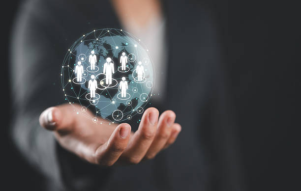 istock Businessman hand holding a digital sphere with human figure models inside. 2240338042