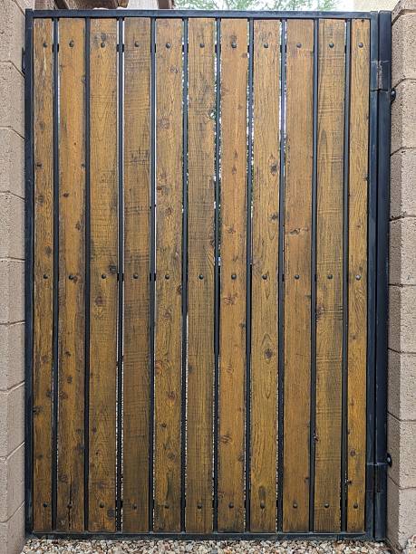 istock Dark Colored Wooden Gate with Metal Frame 2240338559