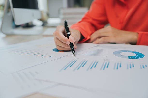 istock Analysis concept. Business professional analyzing financial charts and graphs with a pen on a desk showing detailed data for strategic planning 2240340653