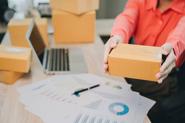 istock E-commerce concept. Delivery person with cardboard box indicating e-commerce success and office productivity in a modern workspace environment 2240341649