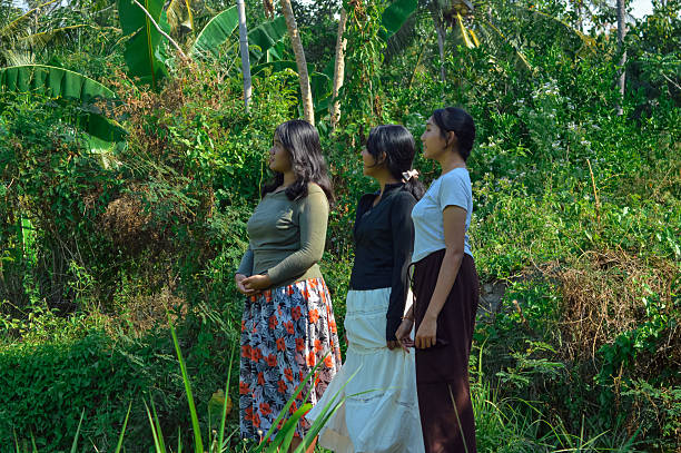 istock Three girls standing quietly facing the same direction outdoors 2240346554