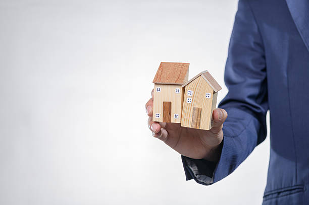 istock Hand Holding Model Houses Representing Real Estate Concept 2240347619