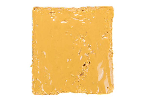 istock A perfectly square slice of toasted bread is shown from a top-down view, completely and generously coated with a smooth, creamy peanut butter or peanut jam. 2240363818