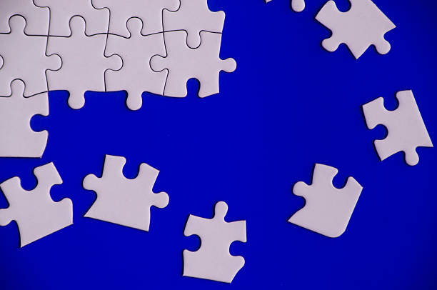 istock Broken pieces of jigsaw puzzles on blue background. 2240364932
