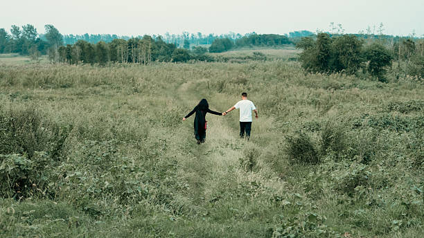 Young Asian couple walking towards the distant wilderness