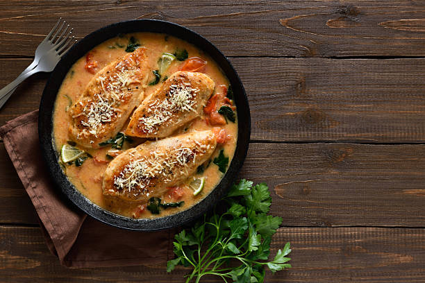 istock Chicken breast in creamy sauce with tomatoes and spinach on plate 2240370947