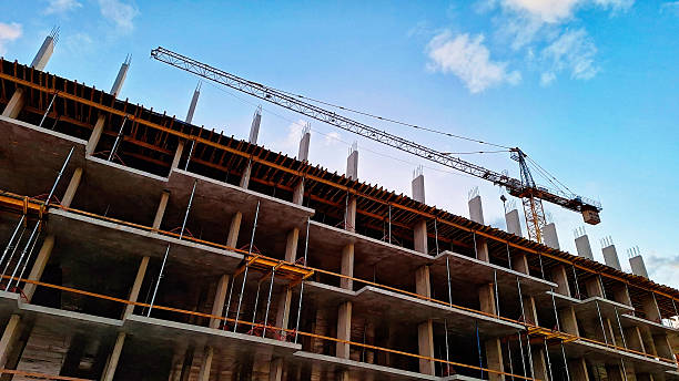 istock A view from below of the construction of a modern monolithic concrete building. Several floors and a construction crane are visible against the sky. 2240377430