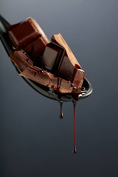istock Melting pieces of bitter chocolate on a black background. 2240382087