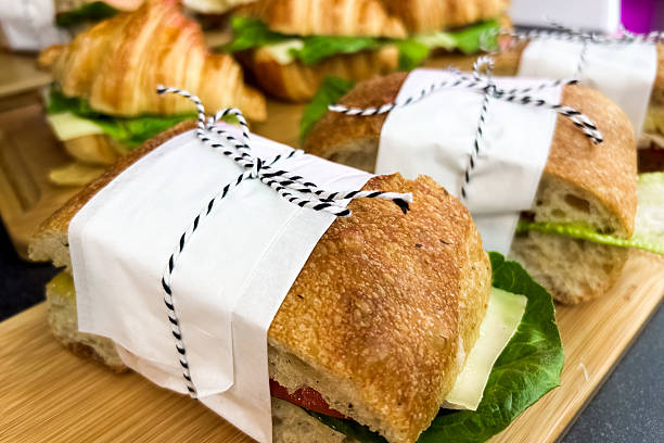 istock Freshly made sandwiches wrapped with care on a rustic wooden board 2240383117