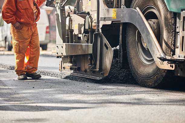 istock Construction workers working on a new asphalt layer on a public street. 2240384052