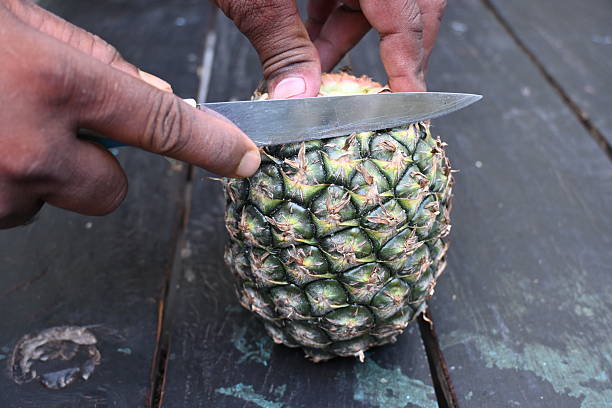 istock Peeling a Pineapple or Ananas comosus with knife. 2240390654