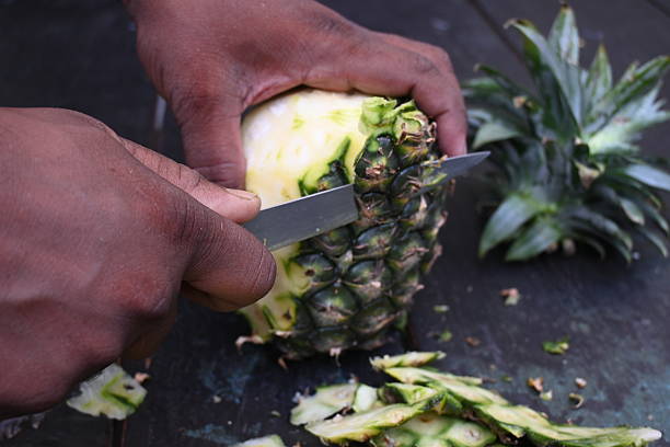 istock Peeling a Pineapple or Ananas comosus with knife. 2240390665