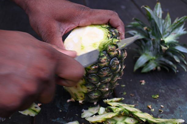 istock Peeling a Pineapple or Ananas comosus with knife. 2240390768