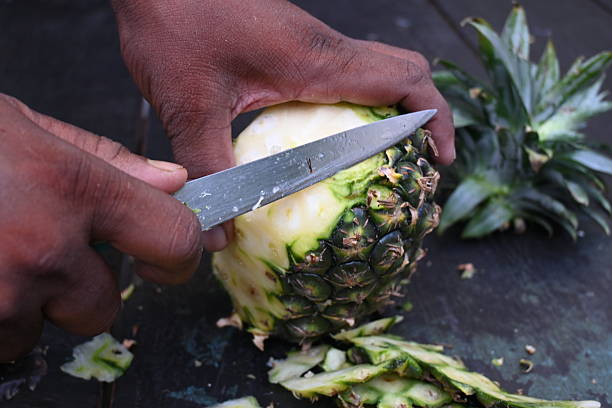 istock Peeling a Pineapple or Ananas comosus with knife. 2240390780