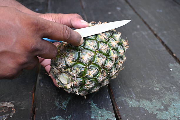 istock Peeling a Pineapple or Ananas comosus with knife. 2240390845