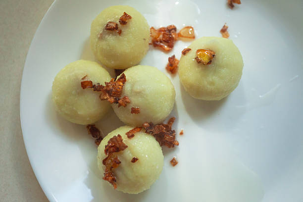 Traditional Polish potato dumplings with fried onions on a plate, top view