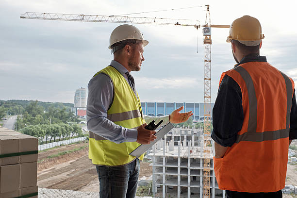istock Man Supervising Construction Site with Coworker 2240392537
