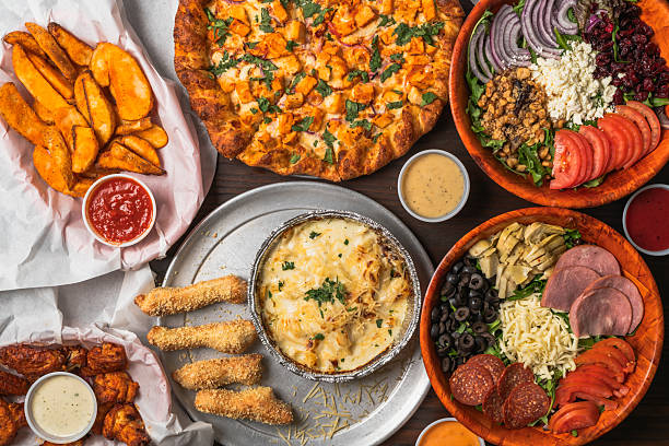 istock Assorted meal spread with pizza, salad, wings, and pasta 2240396021