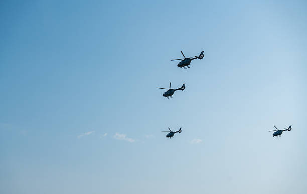 Budapest, Hungary - August 20, 2024: Four helicopters flying in formation against clear blue sky