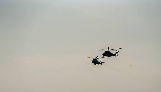 istock Two military helicopters flying in formation against clear sky 2240399620