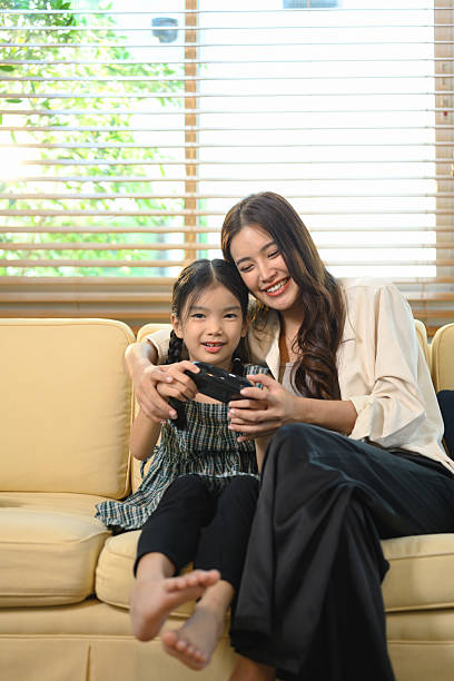 istock Mother teaching her daughter how to play a video game, sharing laughter and learning through fun digital playtime 2240406481
